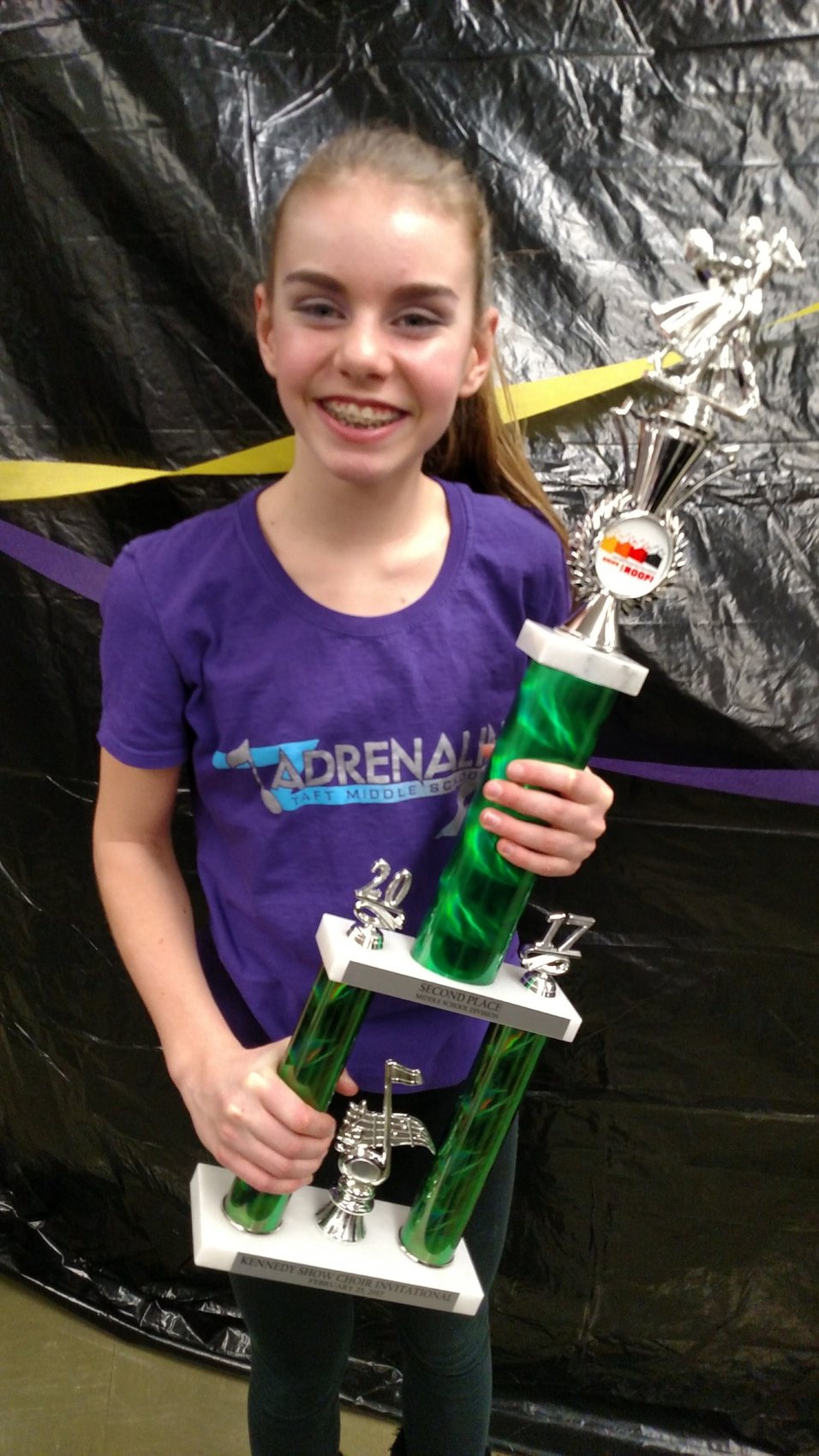 Abbi holding a show choir trophy